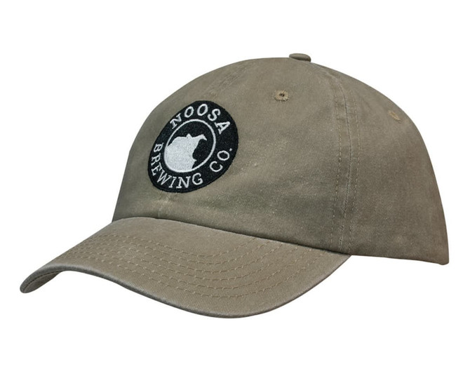 A khaki cap made of enzyme washed pigment dyed cotton twill, featuring a logo on the front.