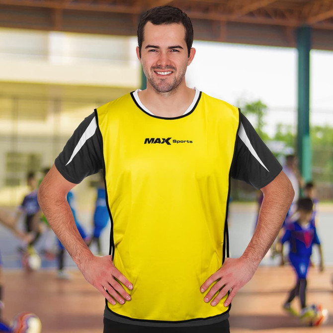 A yellow custom training bib with black accents and a logo, worn by a smiling male model.