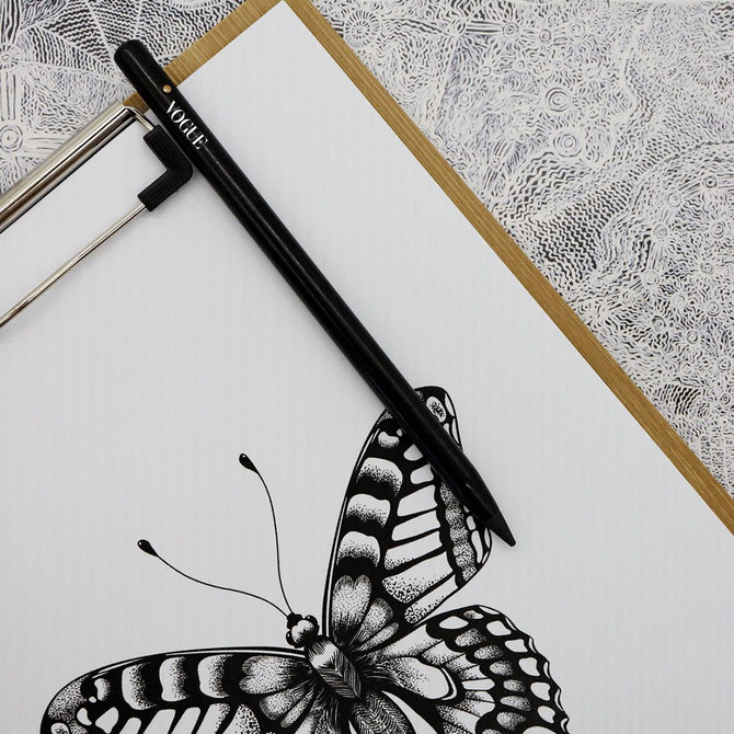 A graphite pencil in black sits atop a white page featuring a detailed butterfly illustration.
