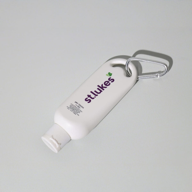 A 50mL white sunscreen bottle with a grey carabiner attached and branding on the front.