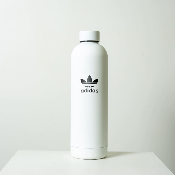 A drink bottle in white with a black logo, featuring a sleek, modern design. Holds 750ml of liquid.