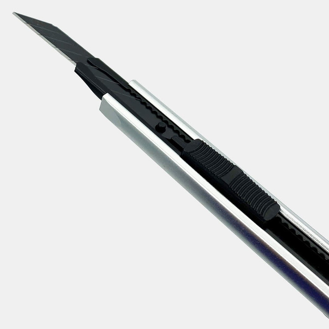 A sleek silver and black retractable box cutter with a rubber grip and blade exposed. It features a logo on the handle.