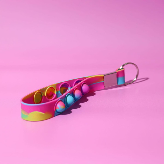 A colourful, pink and blue Popper Stress Reliever Key Chain with multiple popping buttons and a metal keyring.