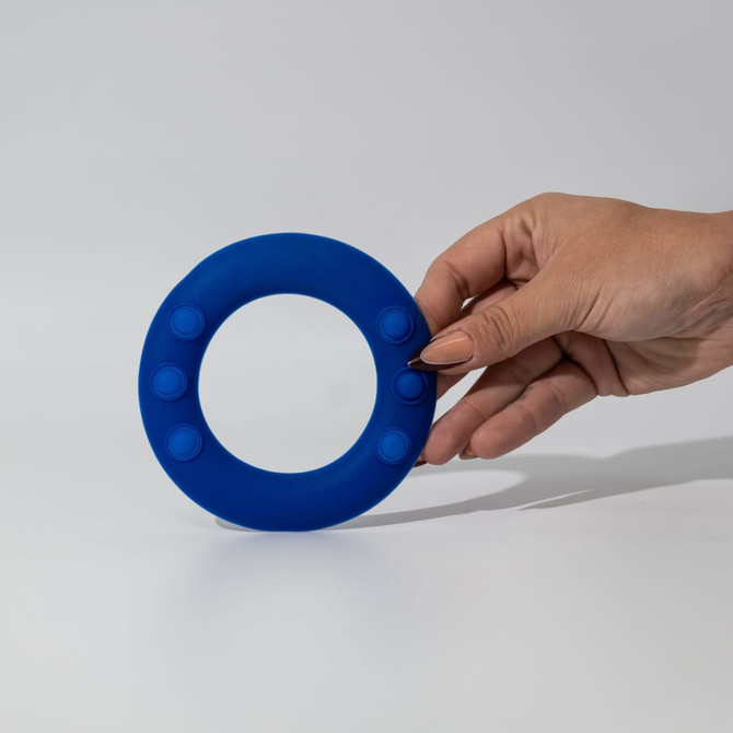A blue silicone wrist disc held in a hand, featuring several raised buttons around its edge.