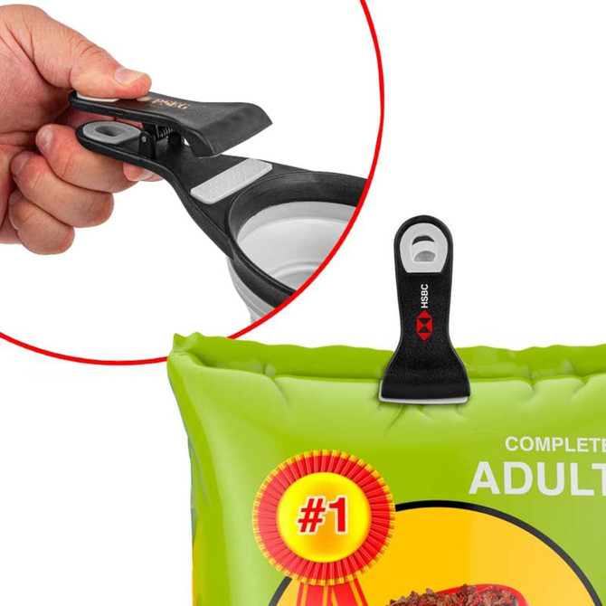 A collapsible silicone pet food scoop in black and grey, with an integrated bag clip for storage. A collapsible silicone pet food scoop in black and grey, with an integrated bag clip for storage.