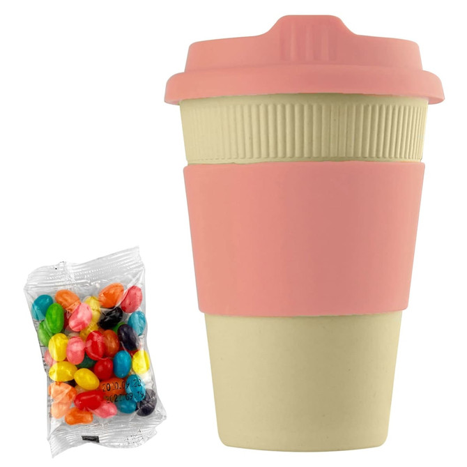 A reusable 12oz bamboo cup in beige with a pink silicone sleeve, accompanied by a pack of colourful jelly beans.