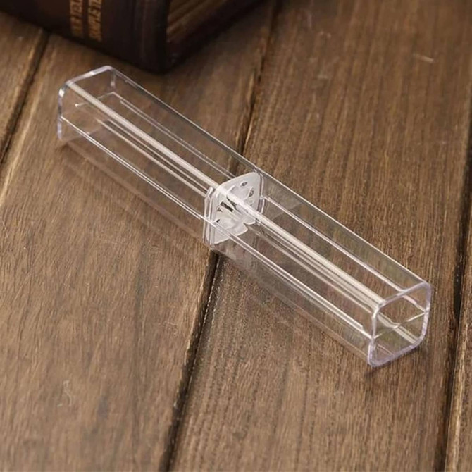 A transparent rectangular pen case with a clear lid, resting on a wooden surface.