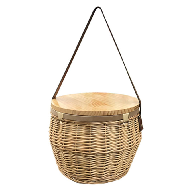 A round wicker picnic cooler basket with a wooden lid and a shoulder strap, showcasing natural tones.