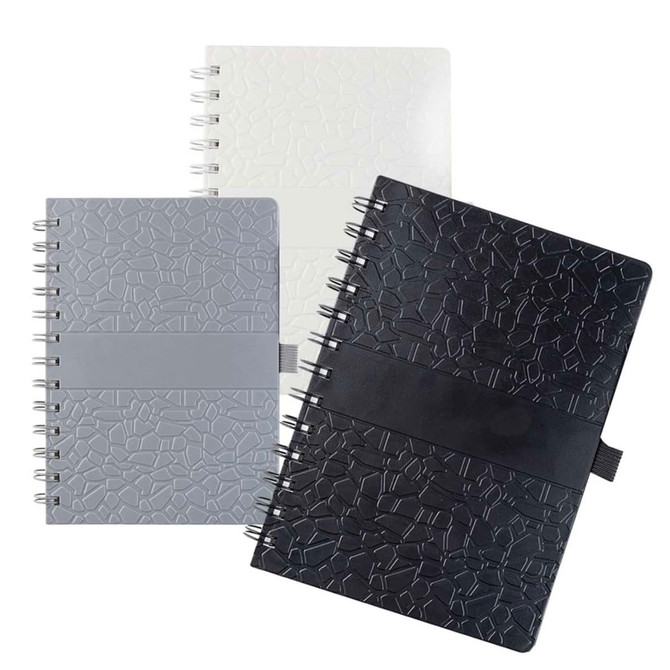 A collection of La Trobe Stone Paper Notebooks in white, grey, and black, featuring textured covers and spiral bindings.