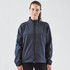 A woman wearing a navy bonded jacket with a high collar and zip front. The jacket features a logo.