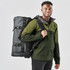 A man carrying a black and green Nautilus Waterproof Duffle 70 bag on his back, wearing a matching jacket.