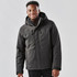 A man wearing a black thermal jacket with a hood, featuring zippered pockets and a stylish design.