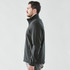 A soft shell jacket in dark grey displayed from the side. Features a zippered pocket and a logo.