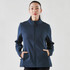 A navy softshell jacket with a front zip and side pockets, worn by a woman. The jacket features a logo.