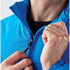 A vibrant blue quilted jacket with a zippered front and high collar, featuring a person adjusting the zipper.