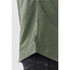 A close-up of a green button-up shirt, featuring a curved hem and a small branding label.