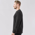 A men's crew neck shirt in dark grey, featuring long sleeves and a fitted silhouette. It has a logo on the front.