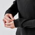 A black crew neck shirt with textured fabric, featuring fitted sleeves and a snug fit around the wrists.