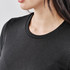 A close-up of a black crew neck shirt featuring a textured fabric and a round neckline.