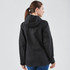 A black women's softshell jacket with a hood, featuring a logo, displayed from the back.