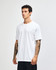 A heavyweight cotton unisex T-shirt in light grey, displayed on a male model. The shirt features a logo.
