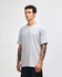 A heavyweight cotton unisex T-shirt in light grey, featuring a relaxed fit and short sleeves. It has a logo.