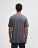 A heavyweight cotton unisex t-shirt in a grey hue, displayed from the back. The shirt has a logo.