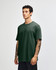 A heavyweight cotton unisex T-shirt in deep green, featuring a crew neck and short sleeves. The design includes a logo.