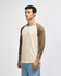 A unisex raglan T-shirt featuring a beige body with brown 3/4 sleeves and a logo.