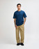 A model wearing a navy blue American Apparel Super Heavyweight T-Shirt paired with olive green cargo pants.