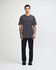 A unisex fine jersey short sleeve t-shirt in black, worn with beige pants and blue sneakers, with a logo visible.