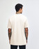 A cream-coloured unisex short sleeve T-shirt, viewed from the back, featuring a logo.