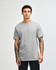 A grey unisex CVC short sleeve T-shirt on a model with a plain background, featuring a logo.