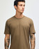 A unisex short sleeve t-shirt in a muted brown colour, displayed on a model. Features a logo.