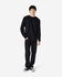 A black long sleeve t-shirt worn by a model, paired with black pants and casual shoes. The shirt has a logo.