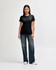 A model wears a black Gildan Softstyle ladies' T-shirt paired with blue jeans and white sneakers, showcasing a casual look.