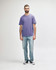 A model wearing a purple Gildan Softstyle Adult Midweight T-Shirt paired with black jeans and sneakers.