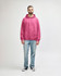 A pink hooded sweatshirt featuring a front pocket, paired with blue jeans and white sneakers.