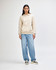 A unisex hooded sweatshirt in beige featuring a front pocket and a soft fleece material, worn with light blue jeans.