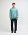 A unisex hooded sweatshirt in mint green, paired with black cargo pants and sneakers, featuring a logo.