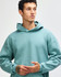 A unisex hooded sweatshirt in a soft green shade, featuring a relaxed fit and a front pocket. It has a logo.
