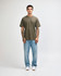 A model wearing an olive green unisex short sleeve T-shirt paired with black cargo pants and sneakers.