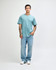 A man wearing a light blue unisex short sleeve t-shirt with denim jeans, standing against a plain background.