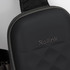 A black, textured bag with a padded surface and a strap, featuring a small logo.