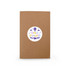 A brown notebook with a circular label featuring colourful text and a logo.