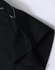 A close-up of a black polo shirt featuring short sleeves and a grey trim detail. The shirt has a logo.