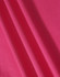 A close-up of textured fabric in a vibrant pink colour, showcasing its structure and weave.