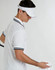 A white visor with a contrasting band and a logo, worn by a person in a white polo shirt.