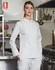A white ladies' functional chef jacket displayed on a model in a professional kitchen setting. The jacket has a logo.