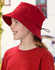 A red bucket hat with a toggle feature, worn by a child, alongside a matching red shirt. The hat has a logo.